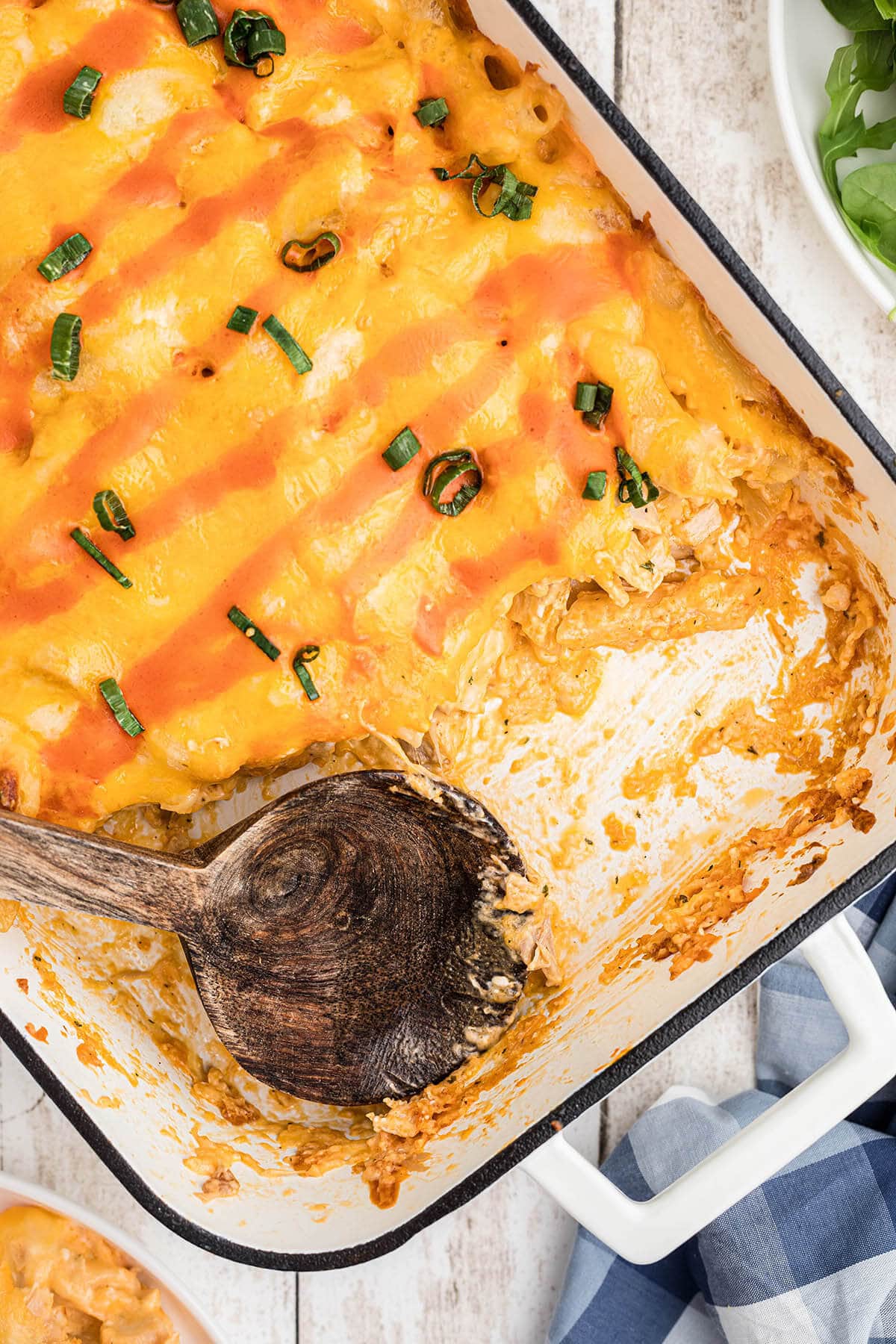 Buffalo Chicken Pasta Bake in casserole dish with serving spoon.