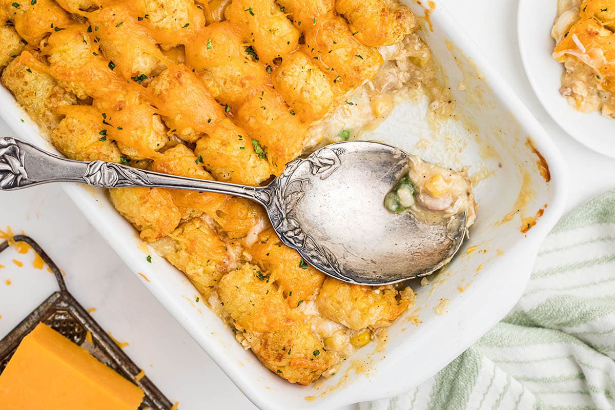 Chicken tater tot casserole in baking dish with spoon.