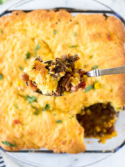 Cowboy Cornbread casserole in baking dish with serving spoon.