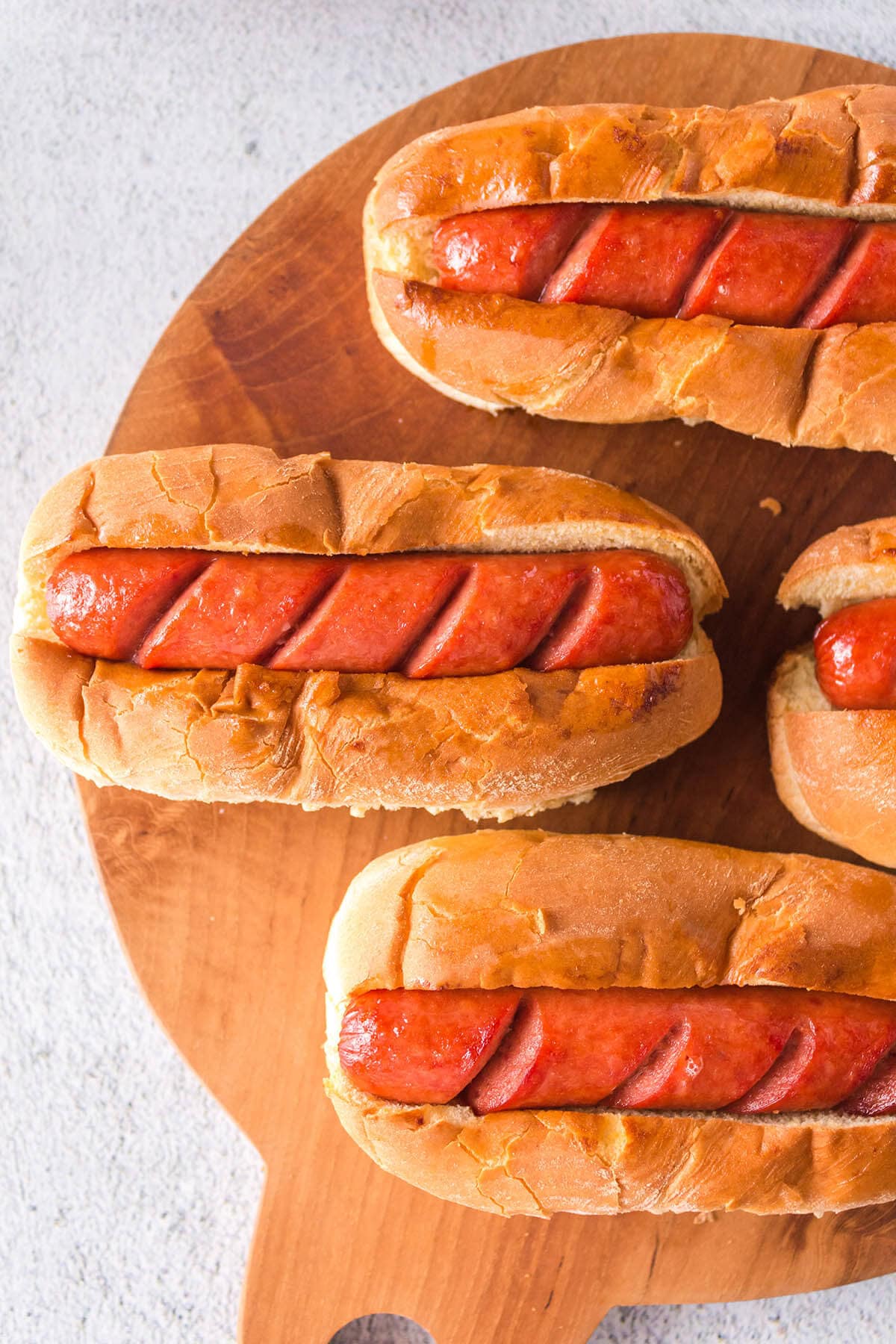 Hot dogs in buns on platter.