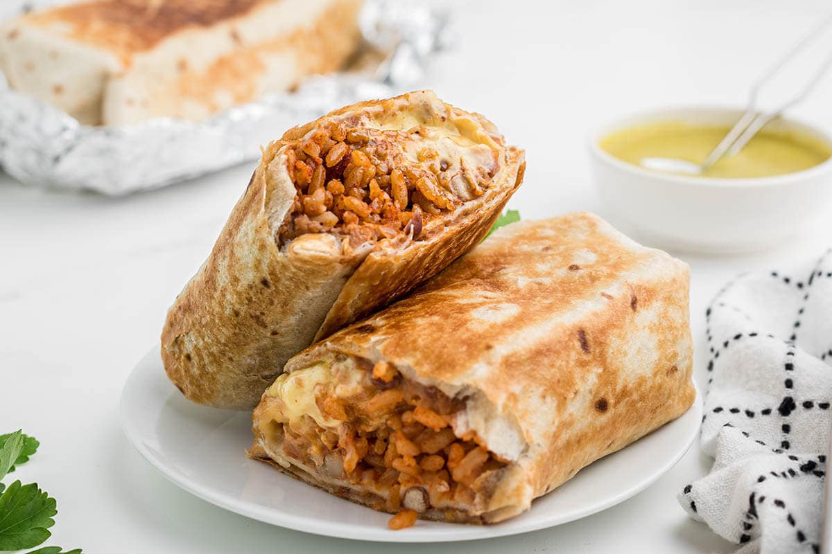 Cheesy bean and rice burrito on plate.