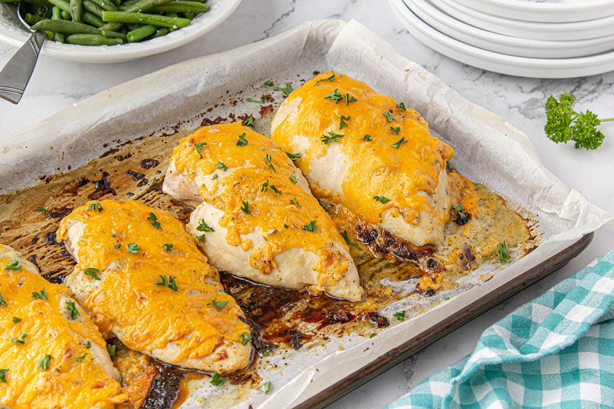 Baked chicken on sheet pan toped with melted chicken.