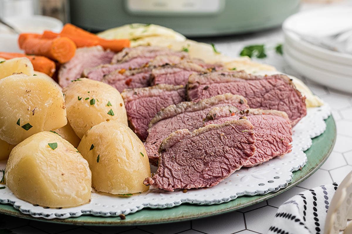 Platter of crock pot corned beef with cabbage, carrots and potatoes.