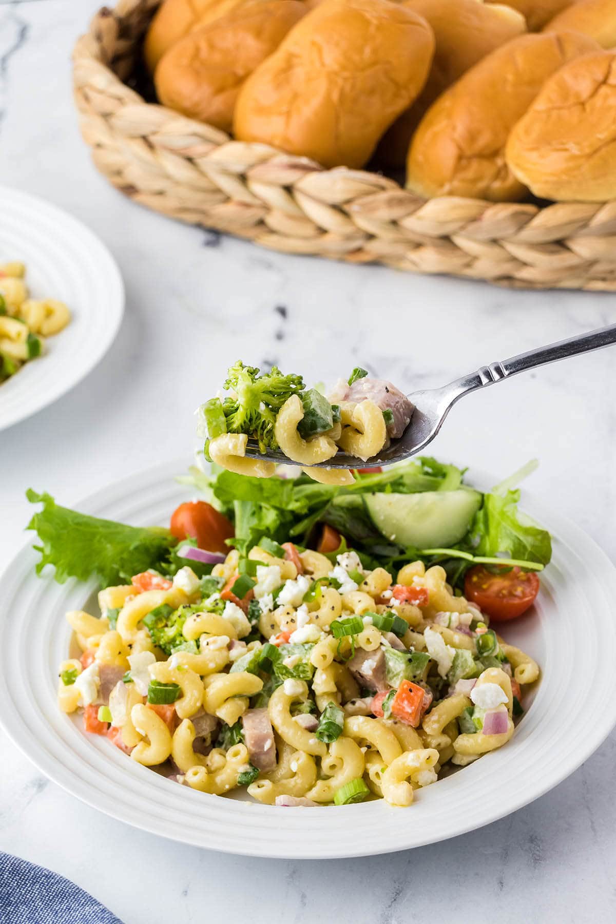 Ham pasta salad on plate with fork.