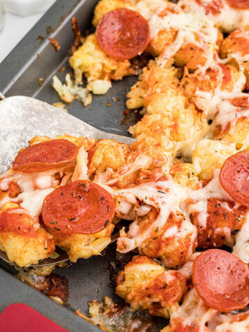 Cheesy pizza tater tot casserole on baking sheet.