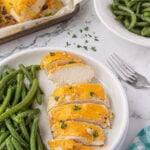 Cheesy ranch chicken on plate with green beans.