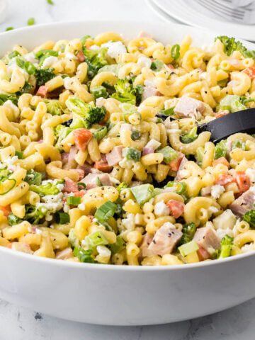 Large bowl of macaroni salad with serving spoon.