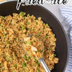 Chicken Fried Rice in a wok with a serving spoon. With print overlay for social media.