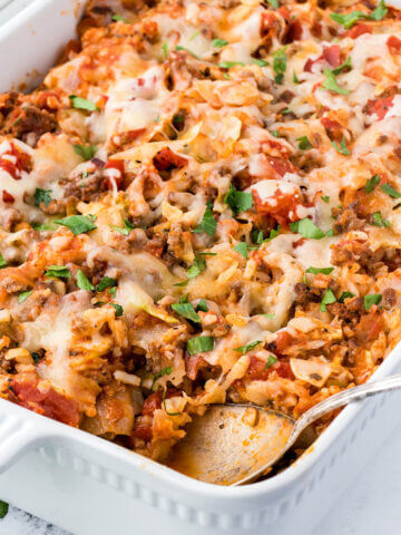 Stuffed cabbage casserole in a baking dish with a serving spoon.