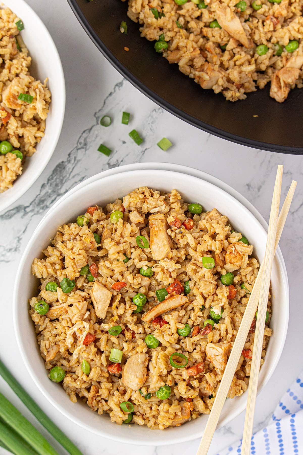 Two bowls of teriyaki chicken fried rice with chopsticks.