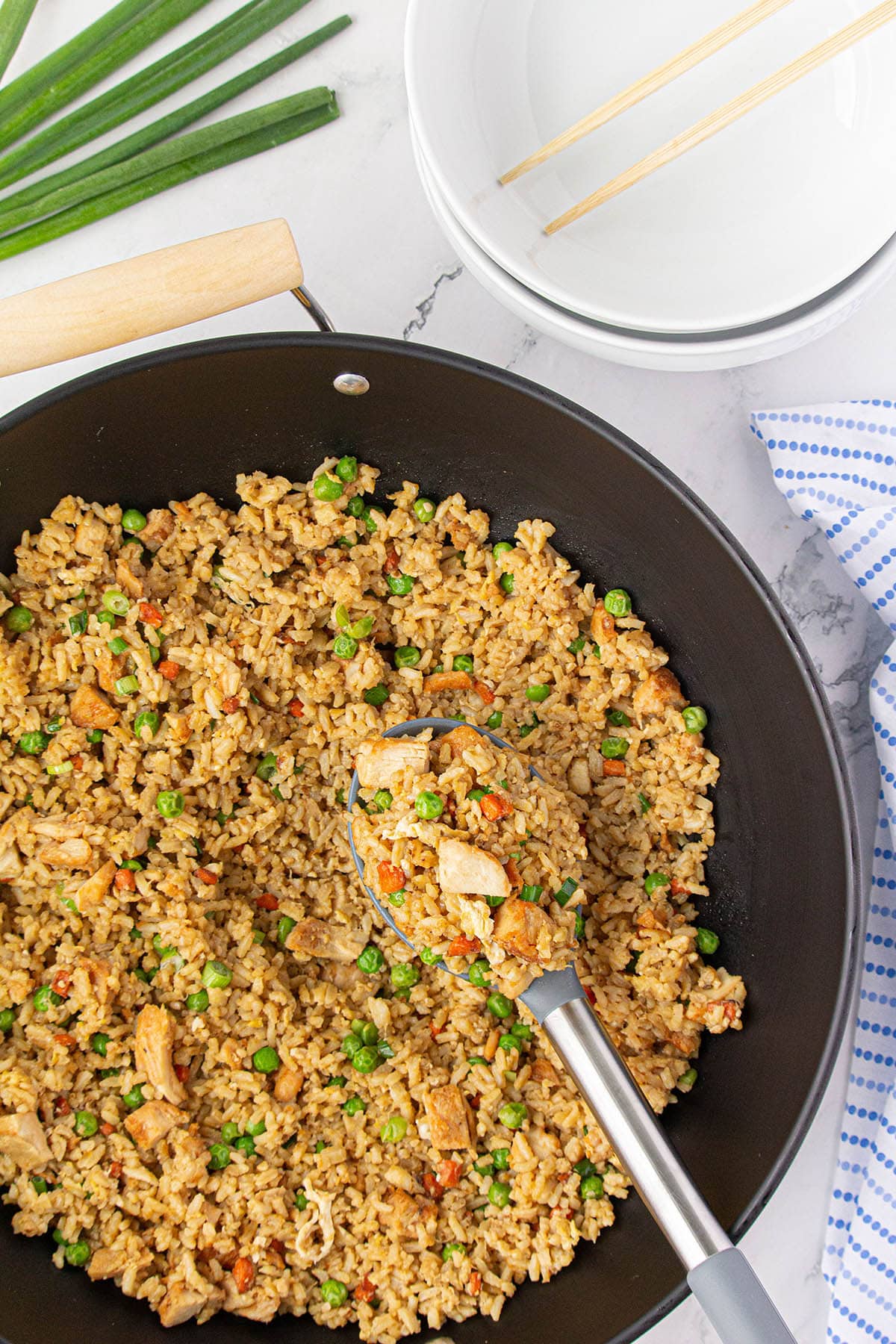 Teriyaki fried rice in a wok with a serving spoon.