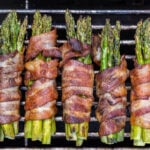 Grilled asparagus wrapped in bacon on bbq grill.