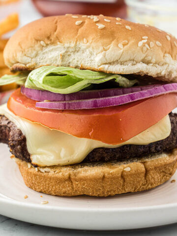 Grilled frozen hamburger on a plate.
