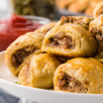 Platter filled with puff pastry sausage rolls.