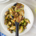 Serving spoon filled with air-fried brussels sprouts.