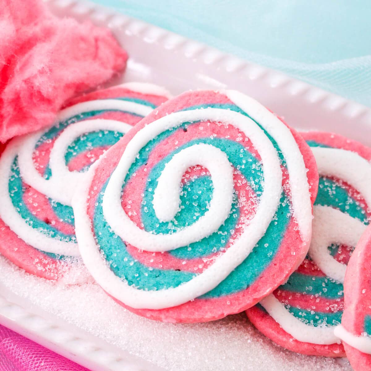 Cotton candy cookies on a white platter decorated with sugar.