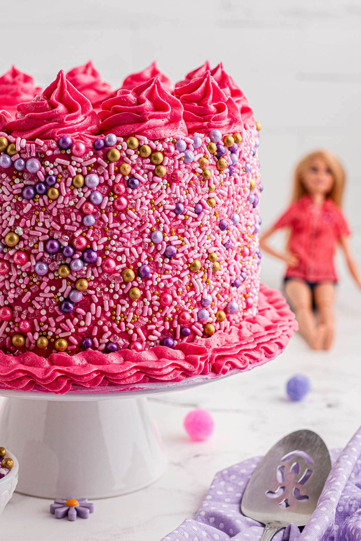Pink funfetti layer cake with a cake knife.