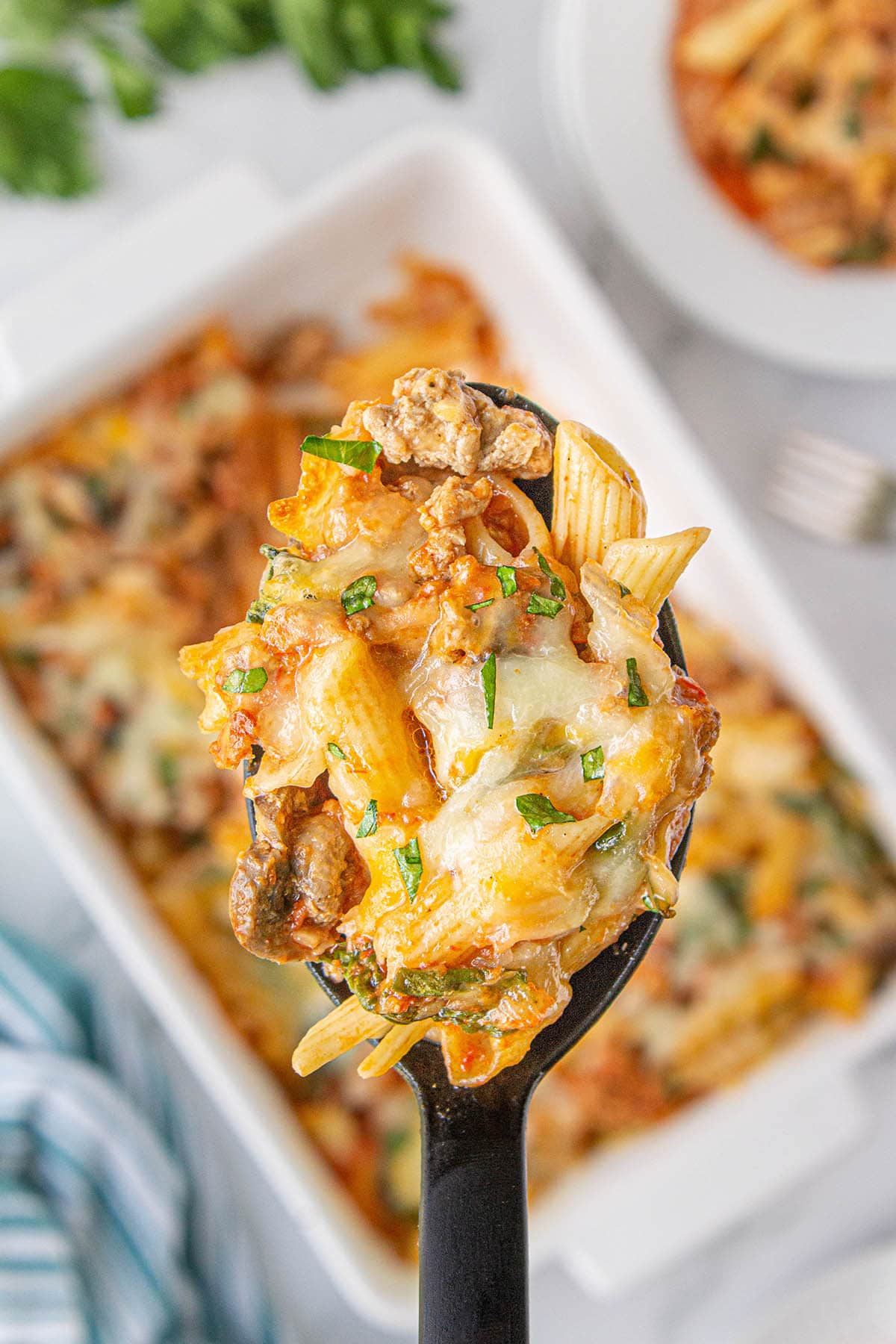 Ground Turkey Casserole in a baking dish with a spoon scooping up a serving.