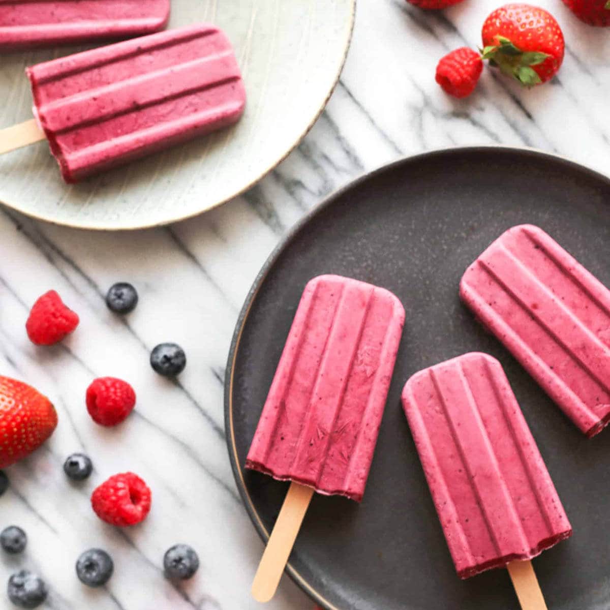 Platters filled with pretty mixed berry yogurt popsicles.
