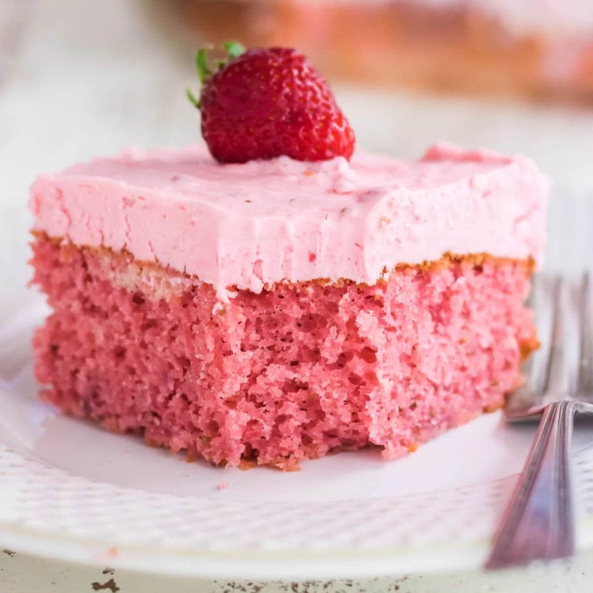 A slice of Pink Strawberry Sheet on a white plate.