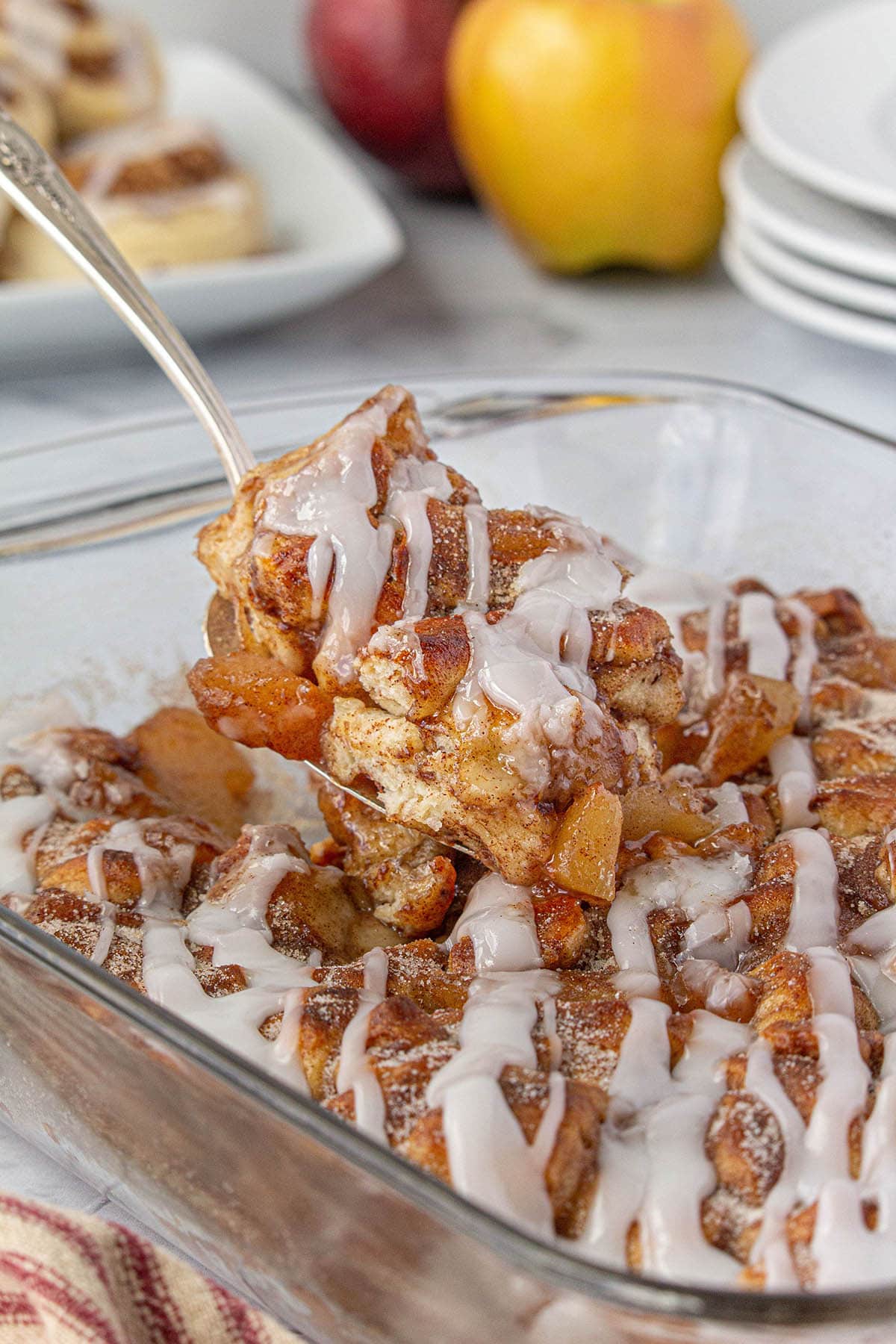 Apple cobbler in casserole dish with a serving spoon.