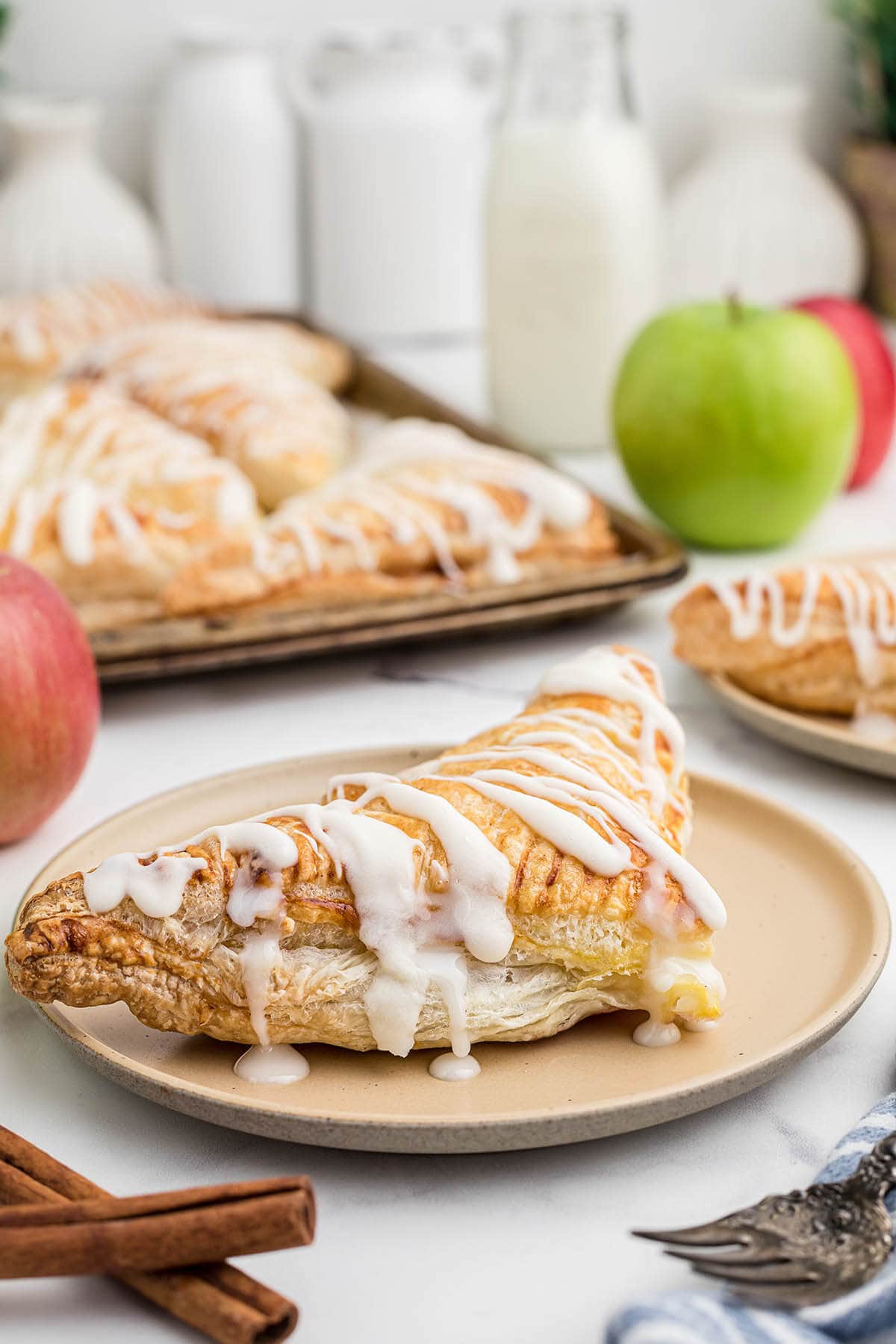Apple hand pie on a plate dripping with icing.