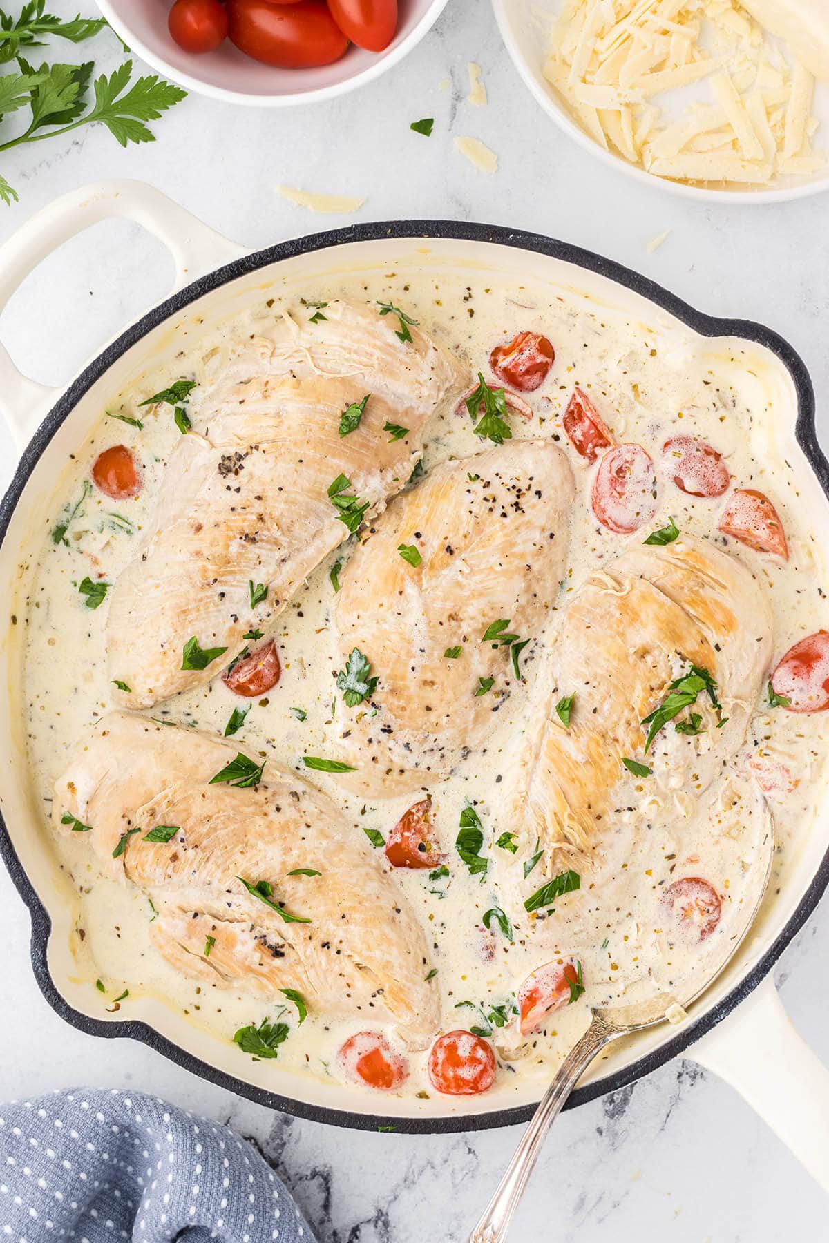 Chicken in a creamy white sauce in a skillet.
