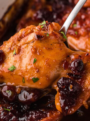 Catalina Cranberry Chicken in casserole dish with a serving spoon.