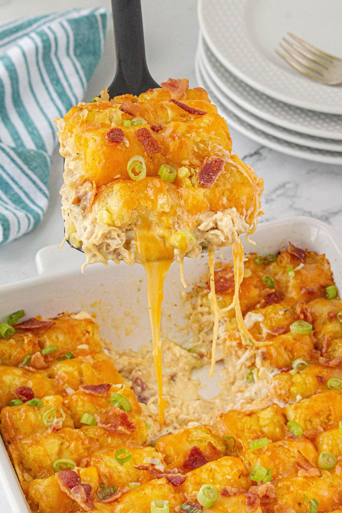 Cheesy Chicken Bacon Ranch Tater Tot Casserole with spatula.