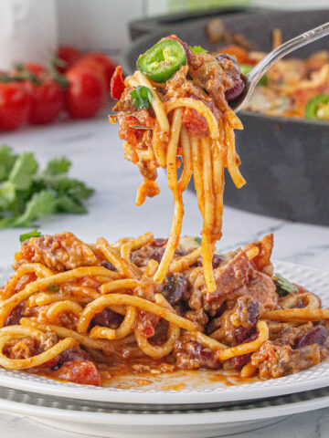 Cowboy spaghetti on a plate with fork twirling the spaghetti.