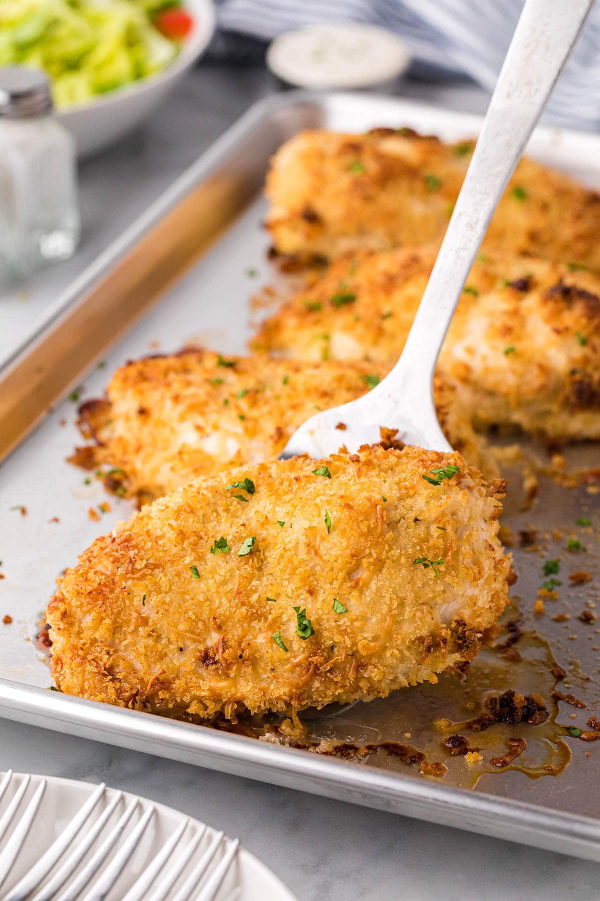 Crispy Ranch Chicken on a sheet pan with a serving spatula.