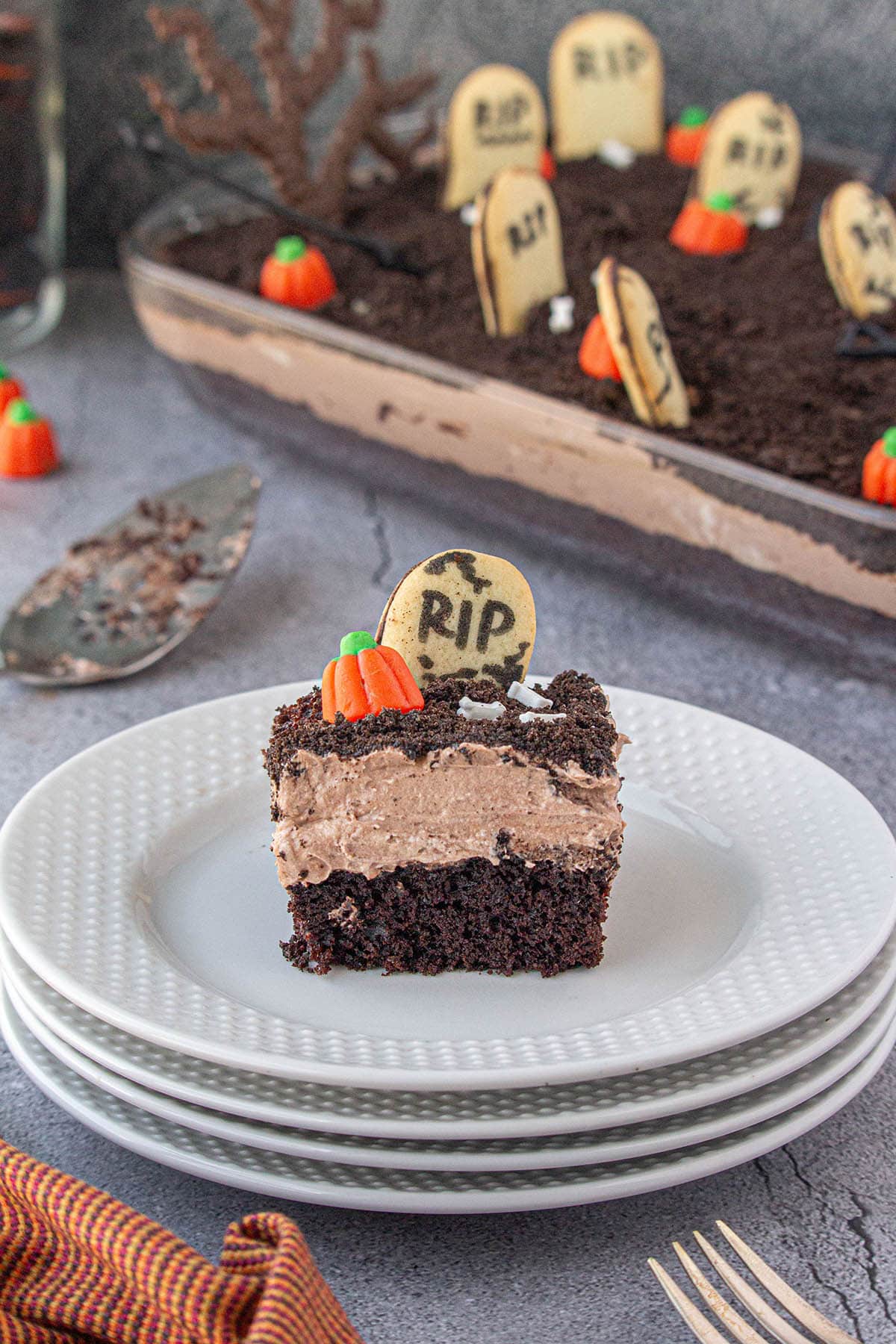 A slice of chocolate cake decorated for halloween on a plate.