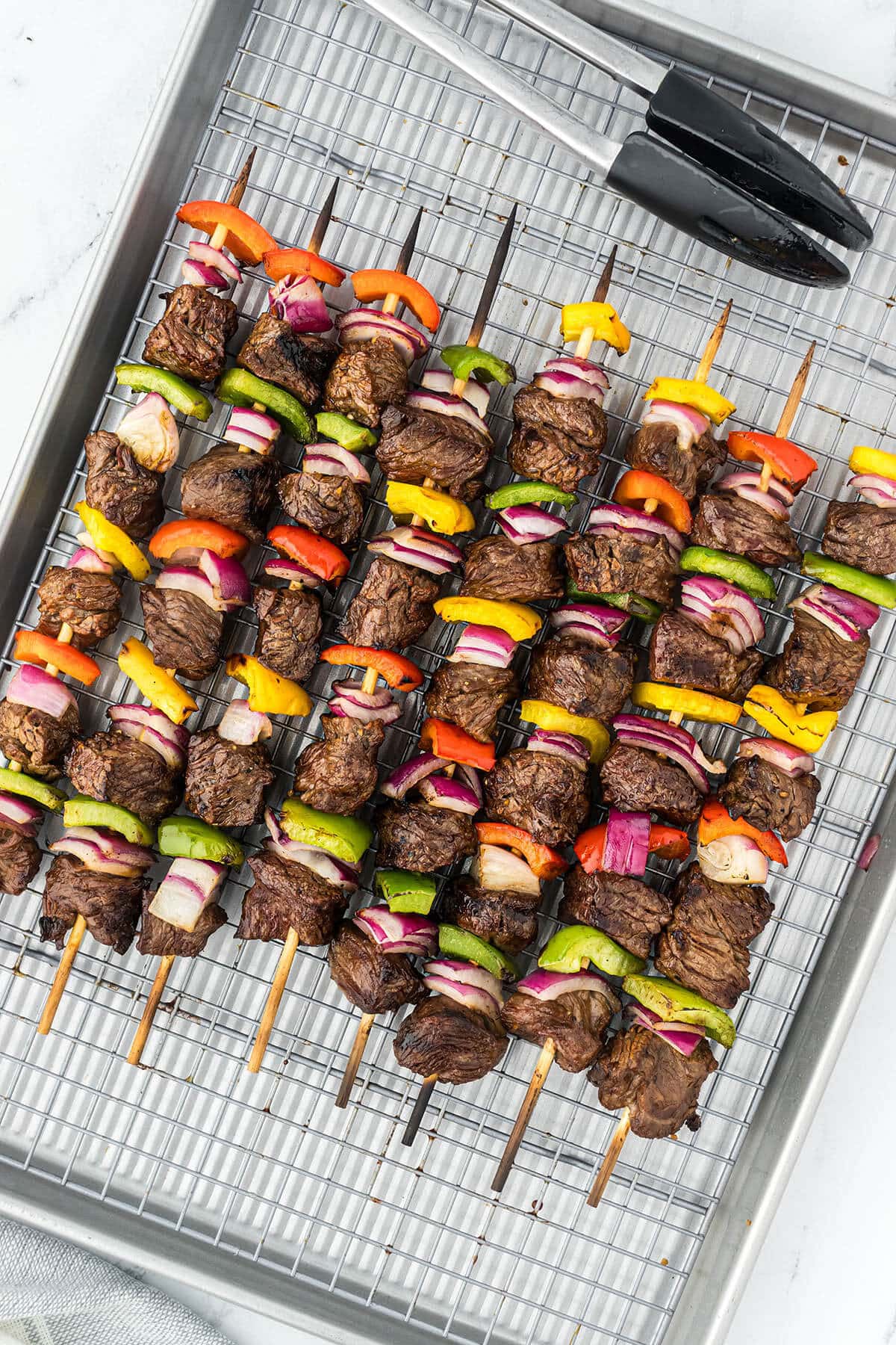 Grilled marinated steak shish kabobs on a platter.