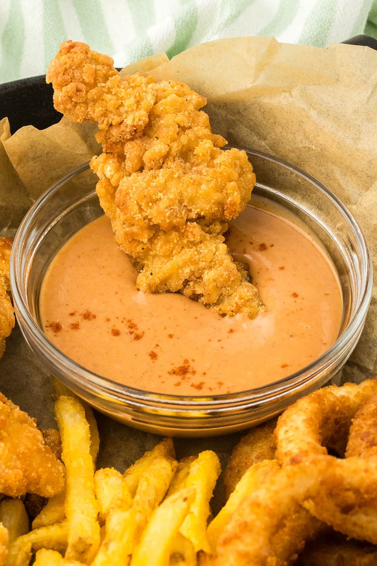 Chicken strips dunked into a bowl of Campfire Sauce.