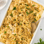 Chicken Alfredo Pasta in a baking dish wish a serving spoon.