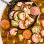 Chicken and Sausage Gumbo in crockpot with serving ladle. With Pinterest overlay.