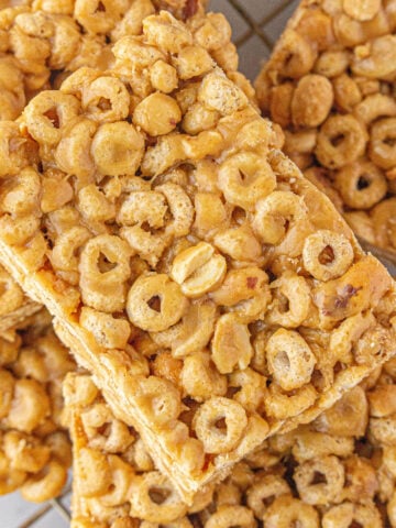 A pile of peanut butter Cheerio bars on a plate.