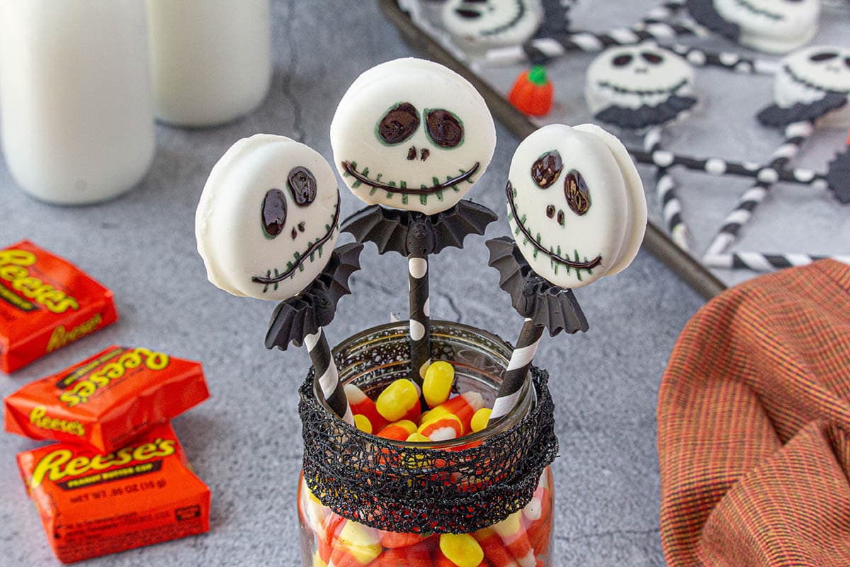 Halloween decorations with a jar of Decorated Halloween Peanut Butter Cups and more on a platter.