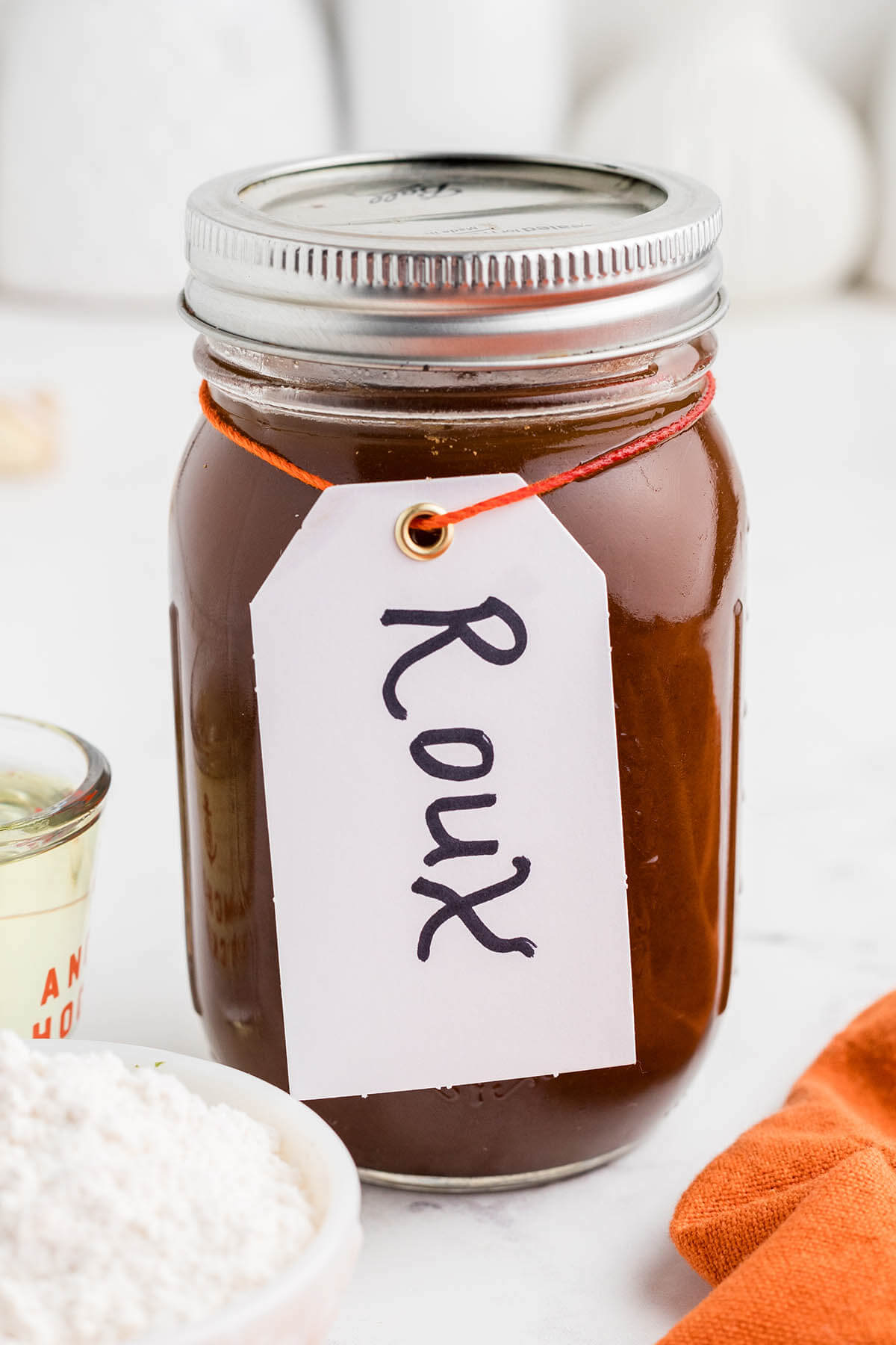 A mason jar filled with dark roux. The jar is labeled as Roux.