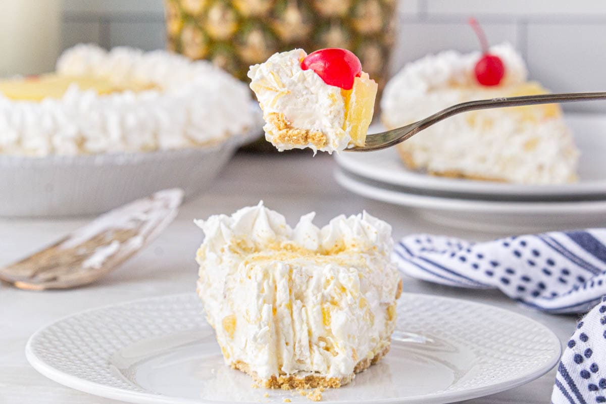 Slice of no-bake pie on a plate with a fork ready to take a bite.