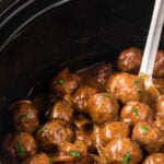Meatballs and Gravy in the Slow Cooke with a serving spoon. With Pinterest overlay.