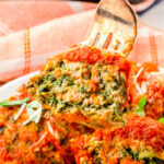 Spinach and turkey meatballs on a plate with a fork. With Pinterest overlay.