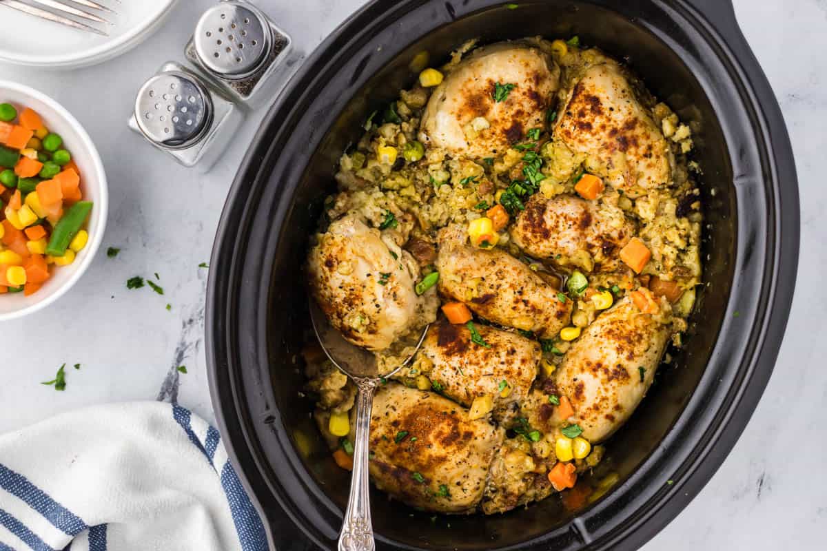 Crockpot Chicken and Stuffing in the slow cooker with a serving spoon.