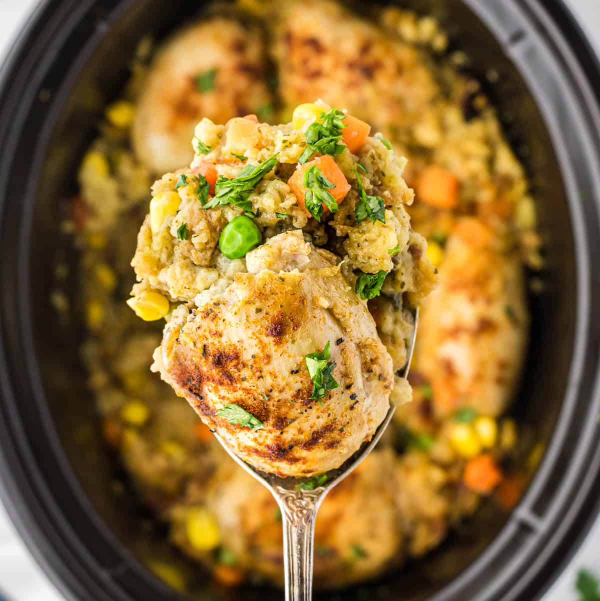 Chicken and Stuffing in a crockpot with a serving spoon dishing up a serving.
