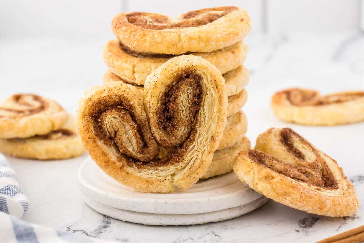 Petite Palmiers stated on a small plate, with additional cookies laying on the counter.