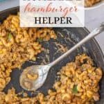Cheesy Homemade Hamburger Helper in a cast iron skillet, with a serving spoon. With print overlay for Pinterest.