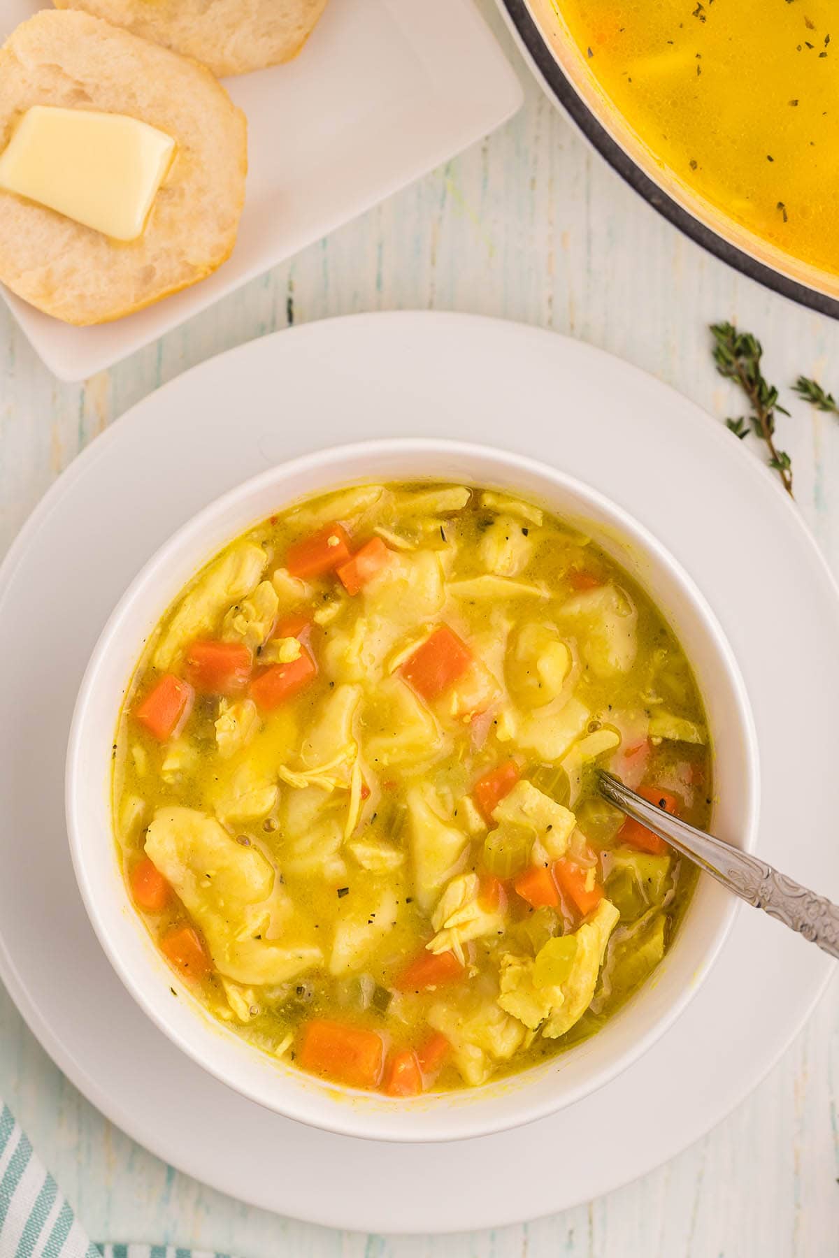 Chicken and Dumpling Soup with Biscuits in a bowl with a spoon.