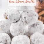 Pecan Bourbon Balls rolled in powdered sugar on a plate. With print overlay for Pinterest.