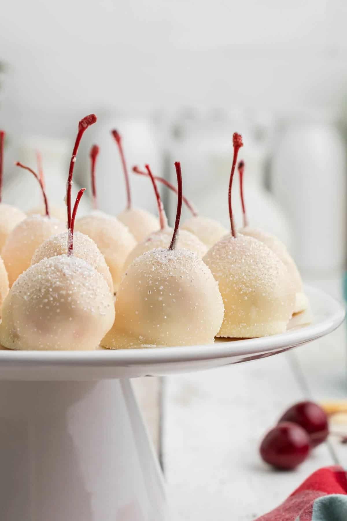 White chocolate covered cherries on a platter.