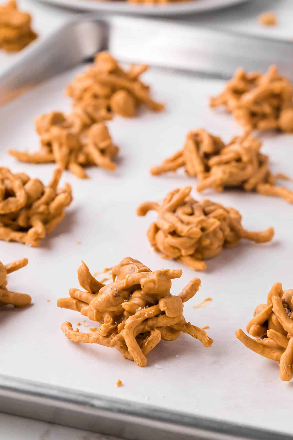 Crunchy butterscotch hay stack cookies on a parchment paper lined cookie sheet.